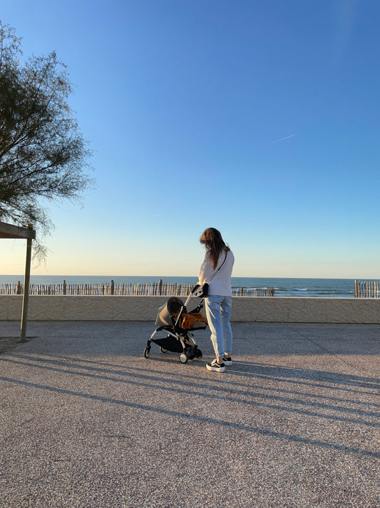 Femme maternité après accouchement en poussette avec son bébé